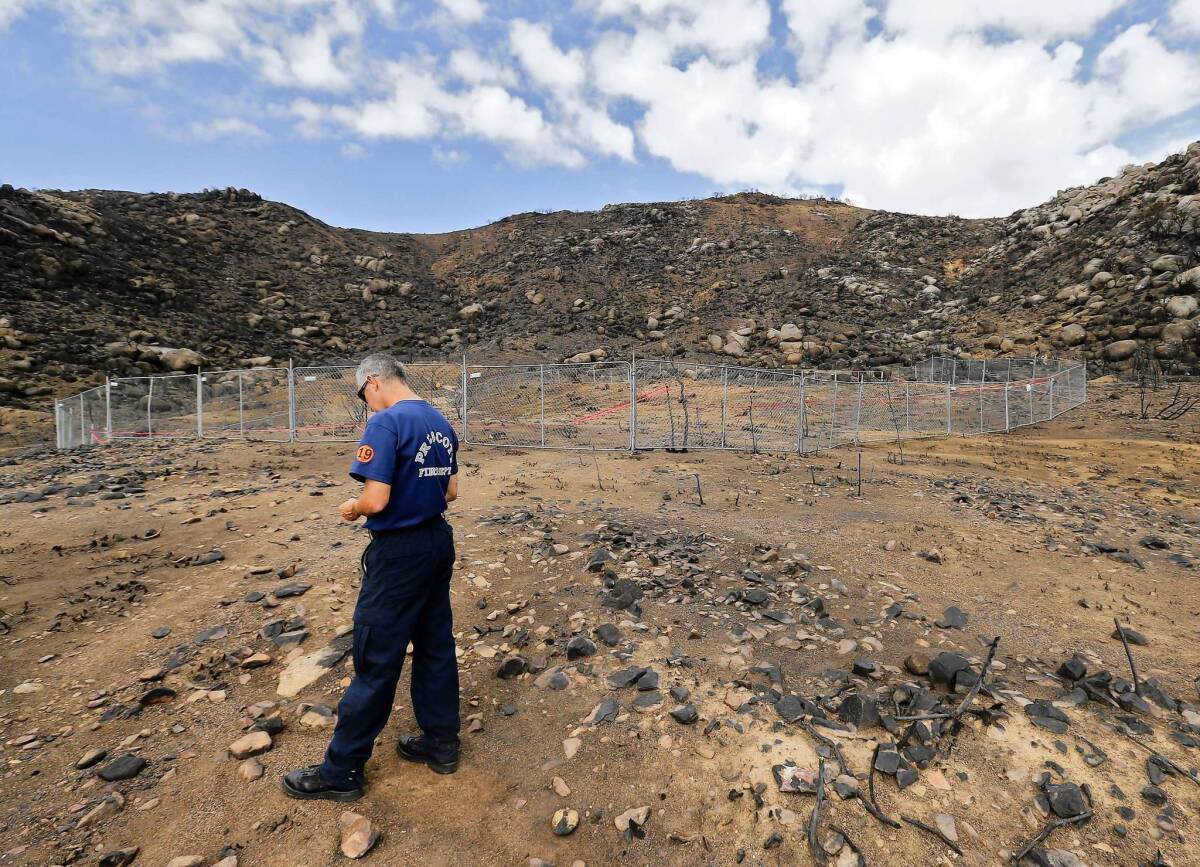 Prescott firefighter Wade Ward visits the site where 19 firefighters died on June 30 fighting the Yarnell Hill fire. Thirteen of those killed were technically part-time workers, and their families are seeking full-time survivor benefits.