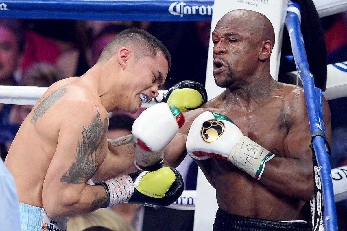 Floyd Mayweather Jr., right, throws a right punch to the face of Marcos Maidana during their welterweight unification title fight in Las Vegas on Saturday night.