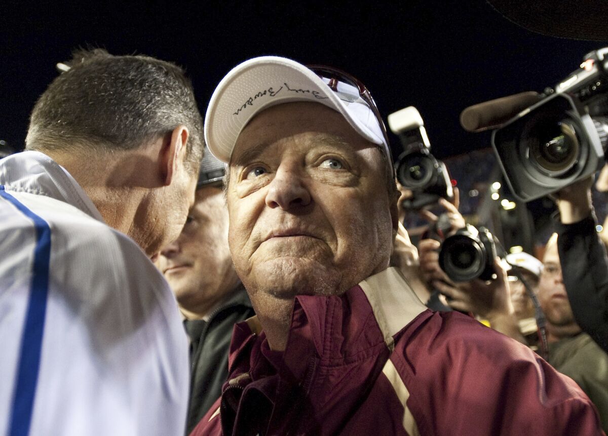 FILE - In this Saturday, Nov. 28, 2009 file photo, Florida State head football coach Bobby Bowden wears a dejected expression as he turns to leave Florida coach Urban Meyer after congratulating Meyer following Florida's 37-10 win over Florida during an NCAA football game in Gainesville ,Fla. The Hall of Fame college football coach Bobby Bowden has died after a battle with pancreatic cancer. Exuding charm and wit, Bowden led Florida State to two national championships and a record of 315-98-4 during his 34 seasons with the Seminoles. In all, Bowden had 377 wins during his 40 years in major college coaching. He was 91 years old. (AP Photo/Phil Sandlin, File)