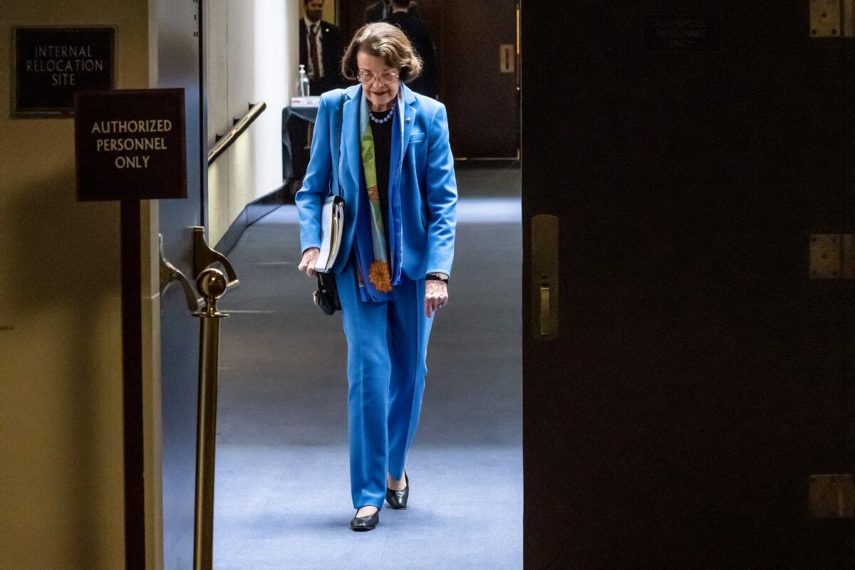 A woman in a blue suit walking through a door