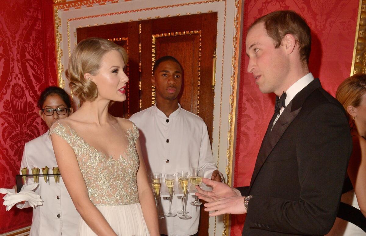 Singer Taylor Swift meets Britain's Prince William, Duke of Cambridge during the Winter White Gala dinner in aid of youth homeless charity Centrepoint at Kensington Palace in London on Nov. 26, 2013.