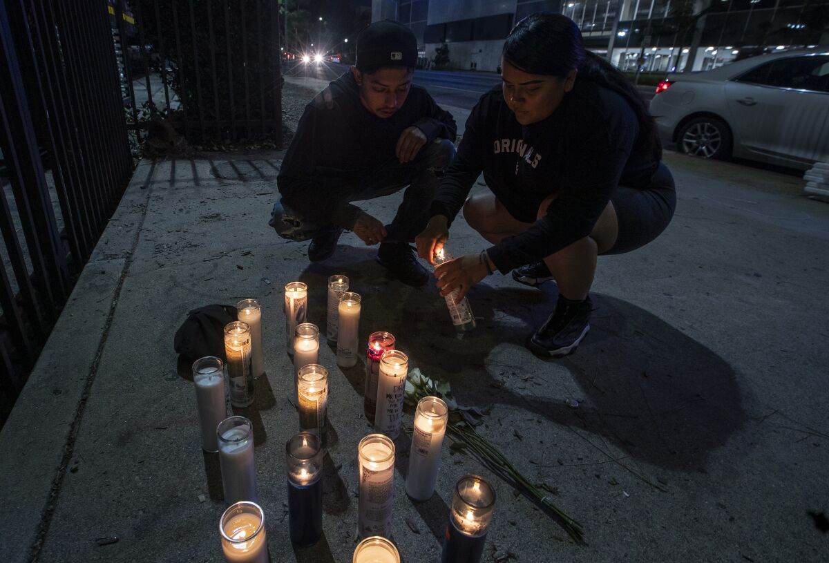 Mourners light candles at a makeshift memorial