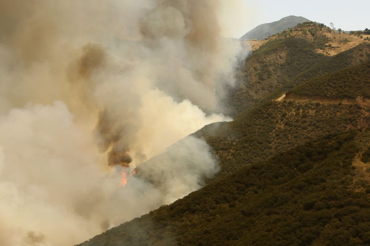 Flames and smoke from the Springs fire can be seen in the mountains above Malibu.