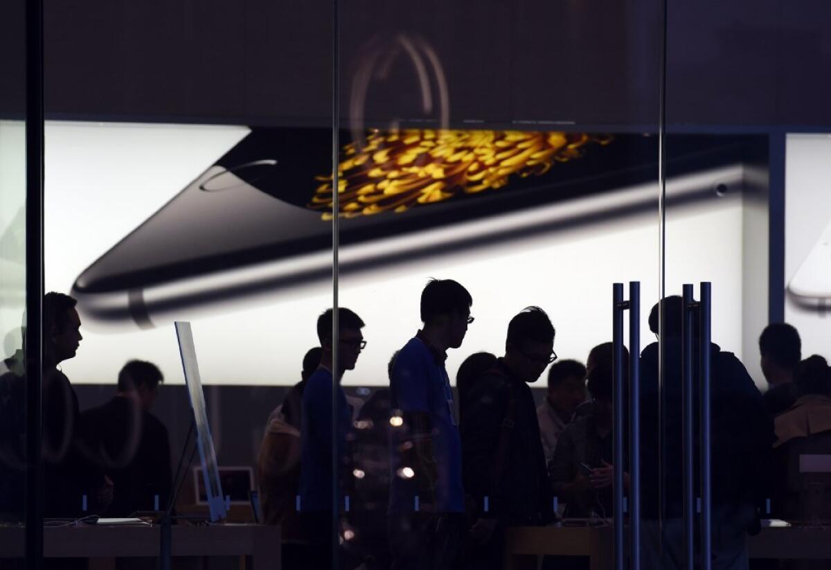 Chinese customers check out devices at an Apple store in Beijing on Thursday.