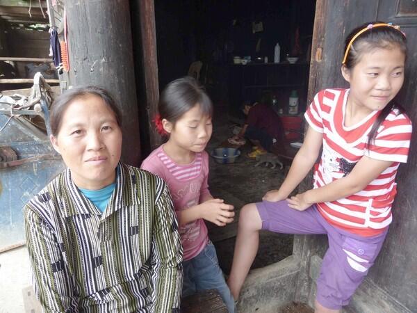 Yang Shuiying and two of her daughters on the front porch of her house in Tianxi village, Guizhou province. Another daughter was taken away by a family planning official, who said he was going to sell the child for foreign adoption.