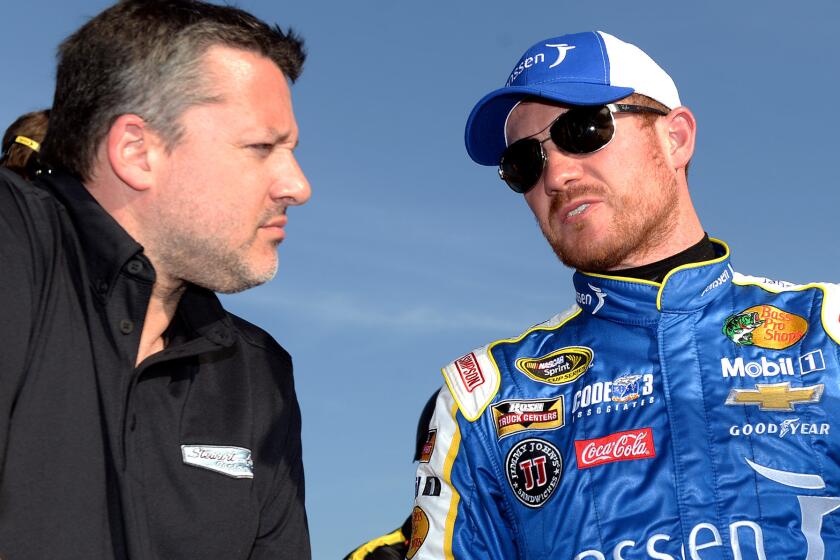 NASCAR driver Brian Vickers, right, speaks with car owner Tony Stewart after qualifying Friday at Auto Club Speedway.