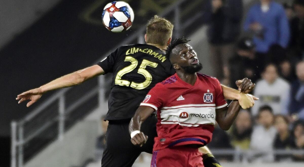 LAFC defender Walker Zimmerman and Chicago Fire forward C.J. Sapong try to head the ball during the second half Saturday.