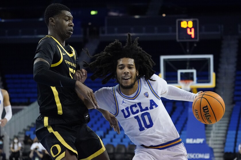 Oregon forward Eric Williams Jr. (50) defends against UCLA guard Tyger Campbell (10) during the first half of an NCAA college basketball game in Los Angeles, Thursday, Jan. 13, 2022. (AP Photo/Ashley Landis)