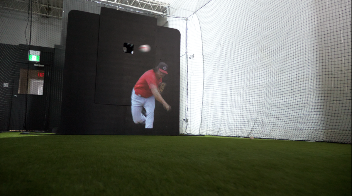A simulation of a pitcher delivering the ball appears while robotic pitching machine called Trajekt Arc is in use. 