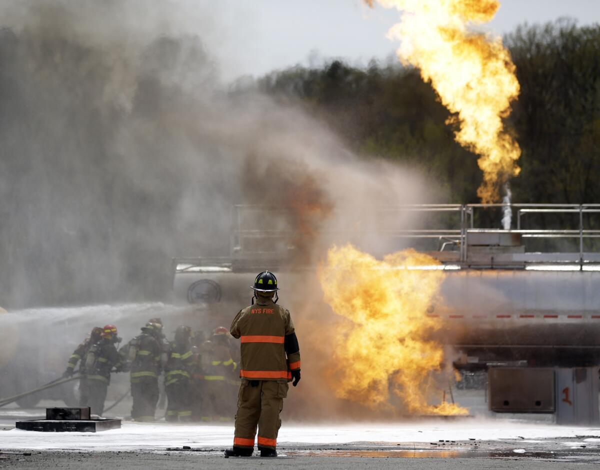 Firefighters douse flames on a tanker truck in a simulated oil spill drill Wednesday in Albany, N.Y.