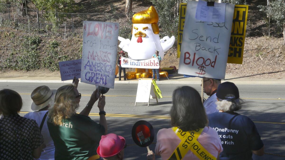 Protesters shouting "not one penny in tax cuts for Issa and the 1 percent" stood on one side of the street and an inflatable 20-foot chicken was set up across from them.