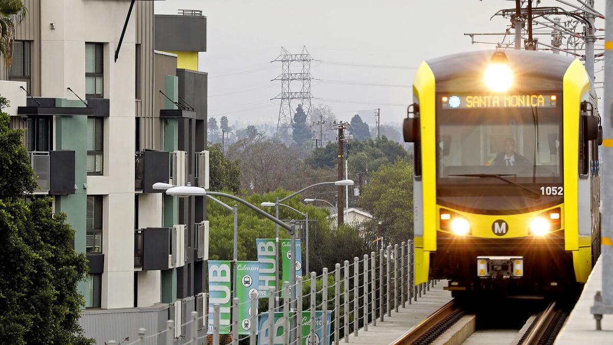 A Metro train on the Expo line passes by apartments in Culver City en route to Santa Monica.
