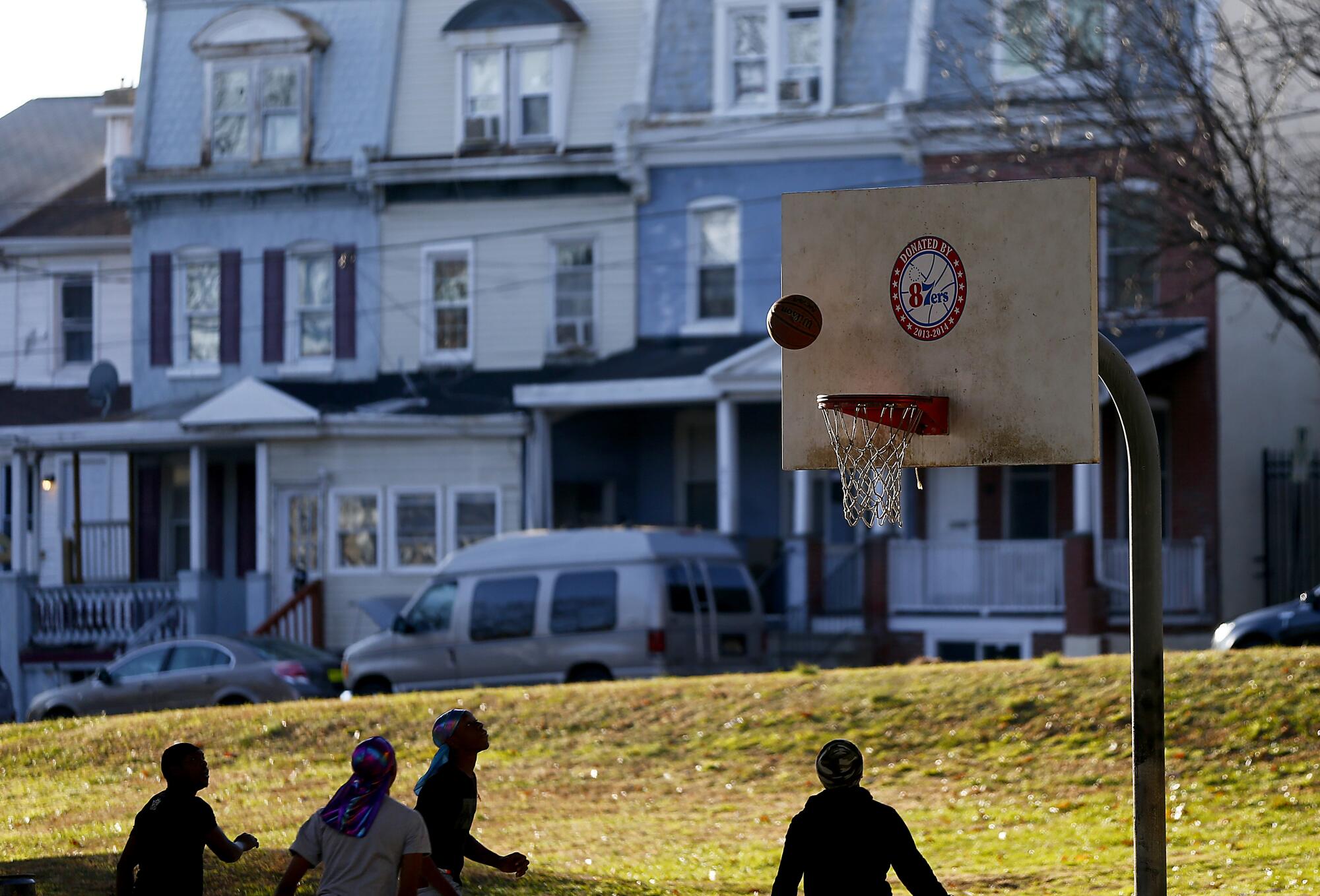 Youths play basketball on a court beneath Interstate 95 in West Wilmington.