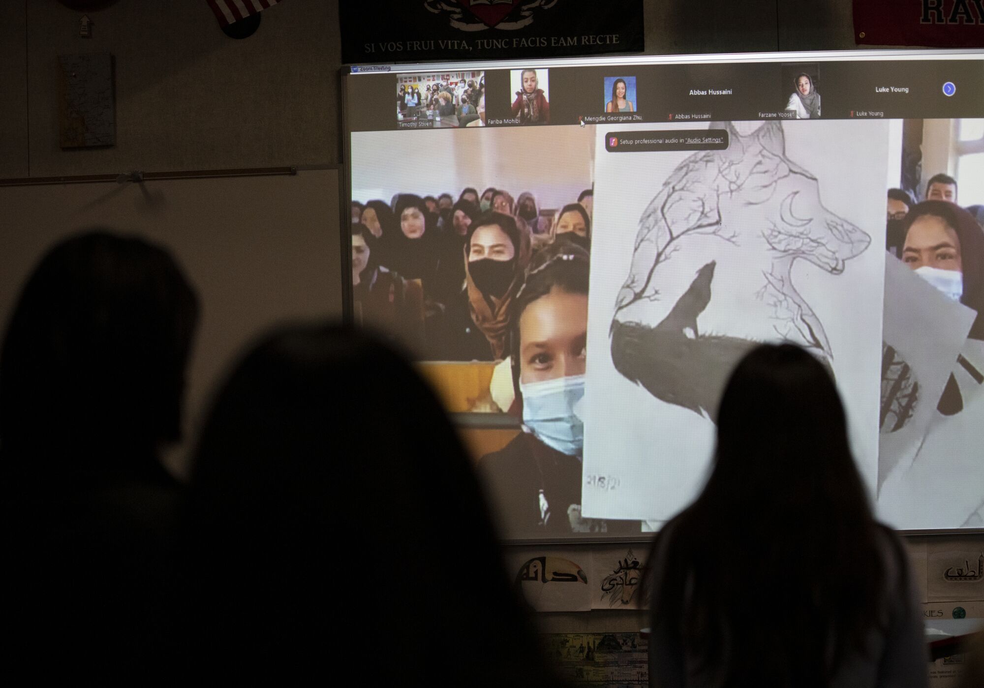 A student in the Mawoud center in Kabul, Afghanistan shows her artwork to Canyon Crest Academy students via Zoom.