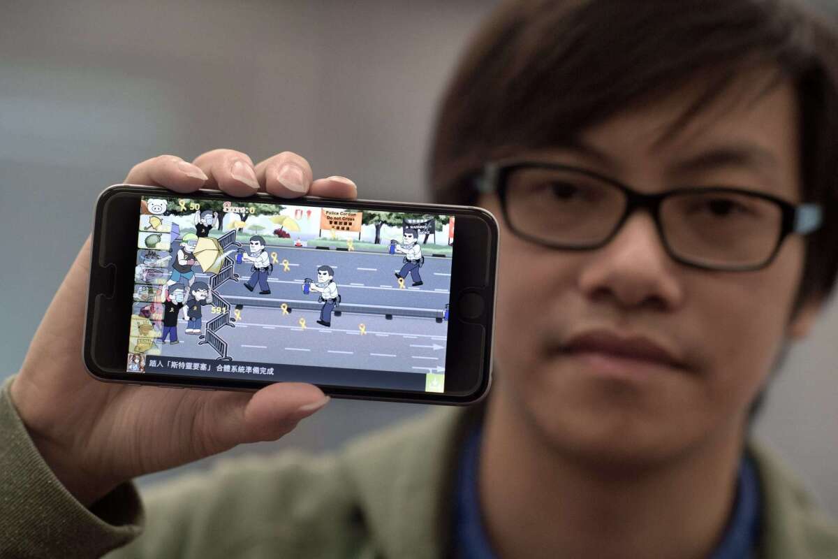 Mobile phone app designer Fung Kam-keung, CEO and founder of Awesapp, holds a smartphone with "Yellow Umbrella" at the company's office in Hong Kong on Oct. 23.