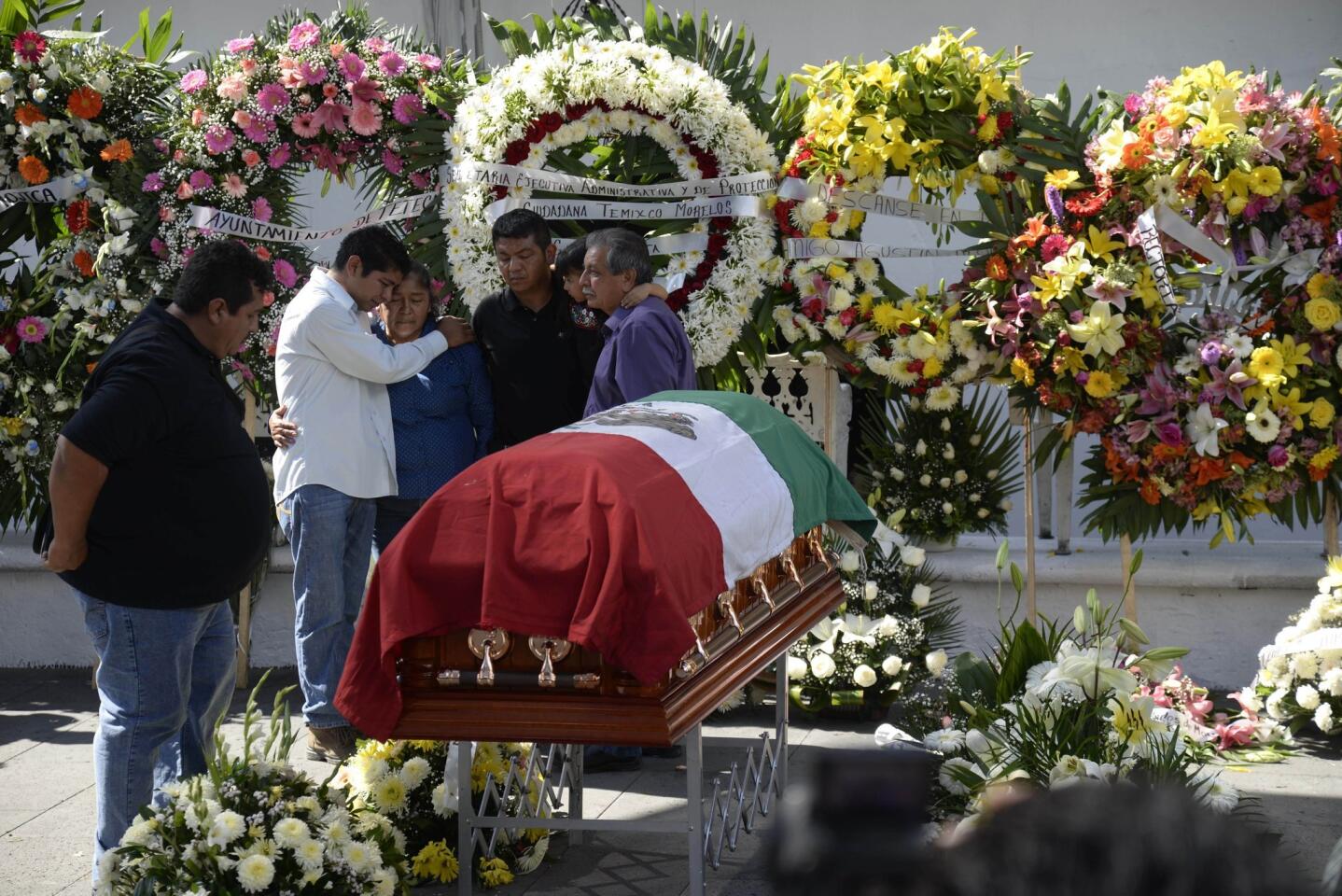 Family members of the slain mayor of Temixco, Gisela Mota, mourn next to her casket, during a ceremony in her honor, at the mayor's office building of Temixco, Mexico, Sunday, Jan. 3. Mota took office as mayor of the city of on Jan. 1 and was shot at her home on Jan. 2. (AP Photo/Tony Rivera)