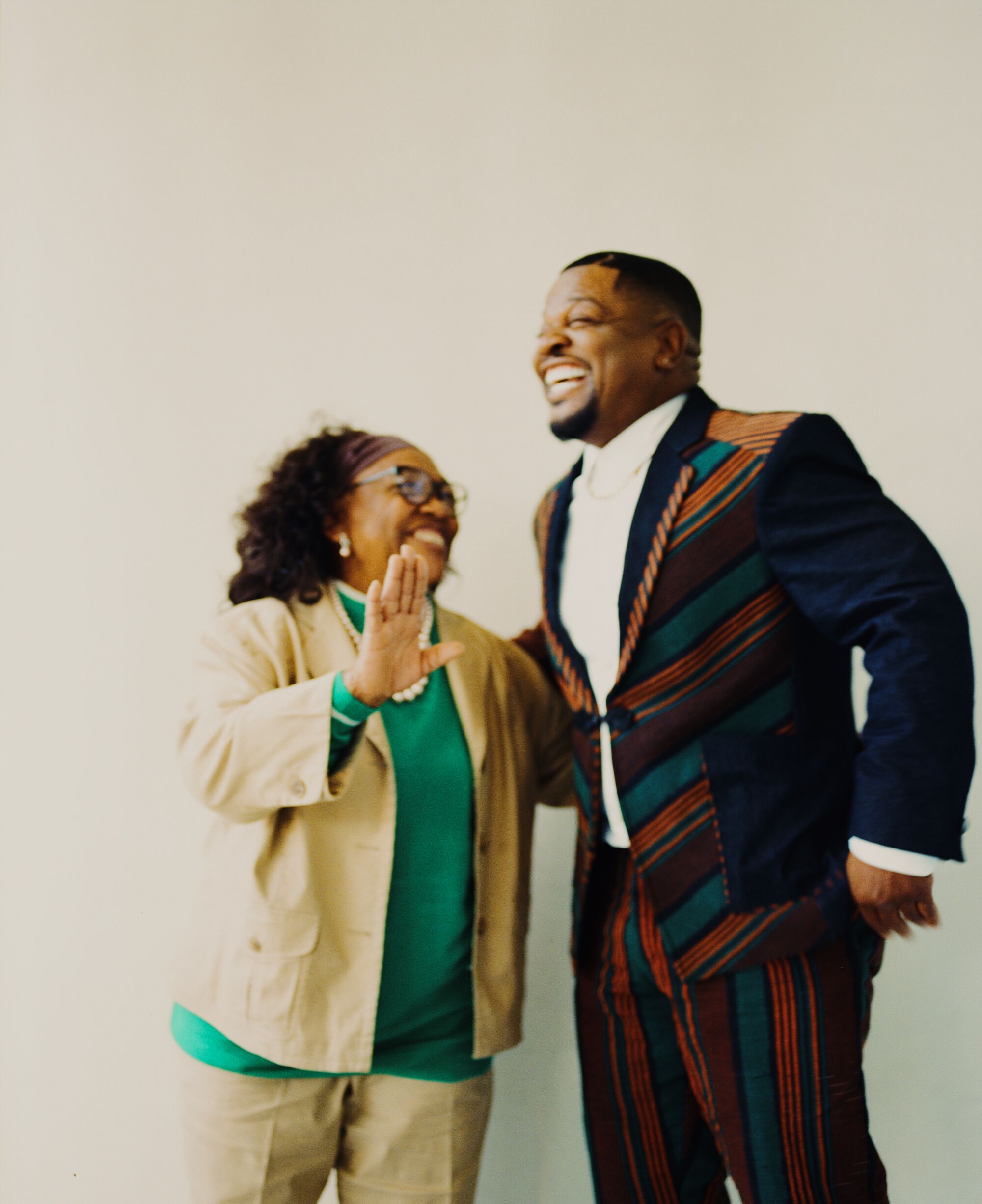 A man and his mother stand laughing together.