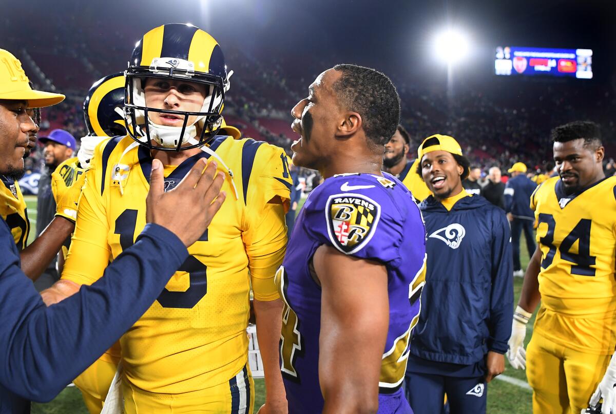TheRavens' Marcus Peters talks to Rams quarterback Jared Goff as they leave the field after the game at the Coliseum on Monday.