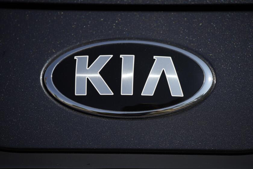 FILE - The company logo shines off the hood of a 2021 K5 sedan on display in the Kia exhibit at the Denver auto show Friday, Sept. 17, 2021, at Elitch's Gardens in downtown Denver. Kia is recalling about 320,000 cars in the U.S. to fix a problem that could stop the trunk from being opened from the inside, Thursday, Aug. 31, 2023. The recall covers the Optima midsize car from 2016 through 2018, Optima hybrids and plug-ins from 2017 and 2018, and the Rio small car from 2016 and 2017. (AP Photo/David Zalubowski, File)