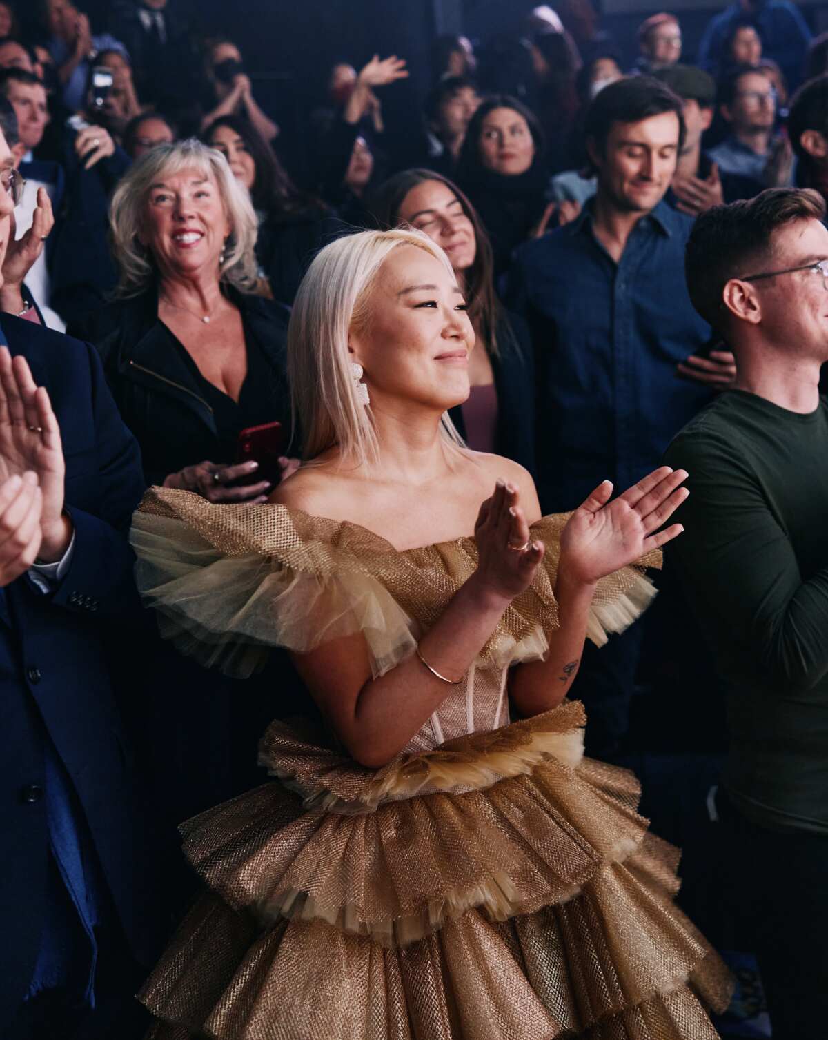 A woman claps along to a performance.