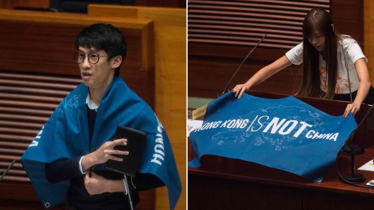 Baggio Leung, left, and Yau Wai-ching with flags that read "Hong Kong is not China" as they take their Legislative Council Oaths in Hong Kong on Oct. 12. They have been disqualified from taking office.
