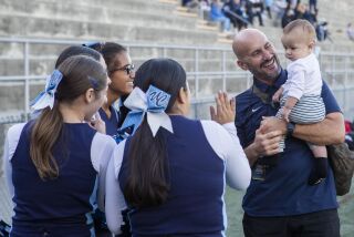 Santee, CA - November 25: University City principal Mike Paredes shows off his daughter Ezra to the cheerleaders during the Division III San Diego Section football championship game against Point Loma at Southwestern College's Richard L. Jantz Stadium on Friday, Nov. 25, 2022 in Santee, CA. (Meg McLaughlin / The San Diego Union-Tribune)