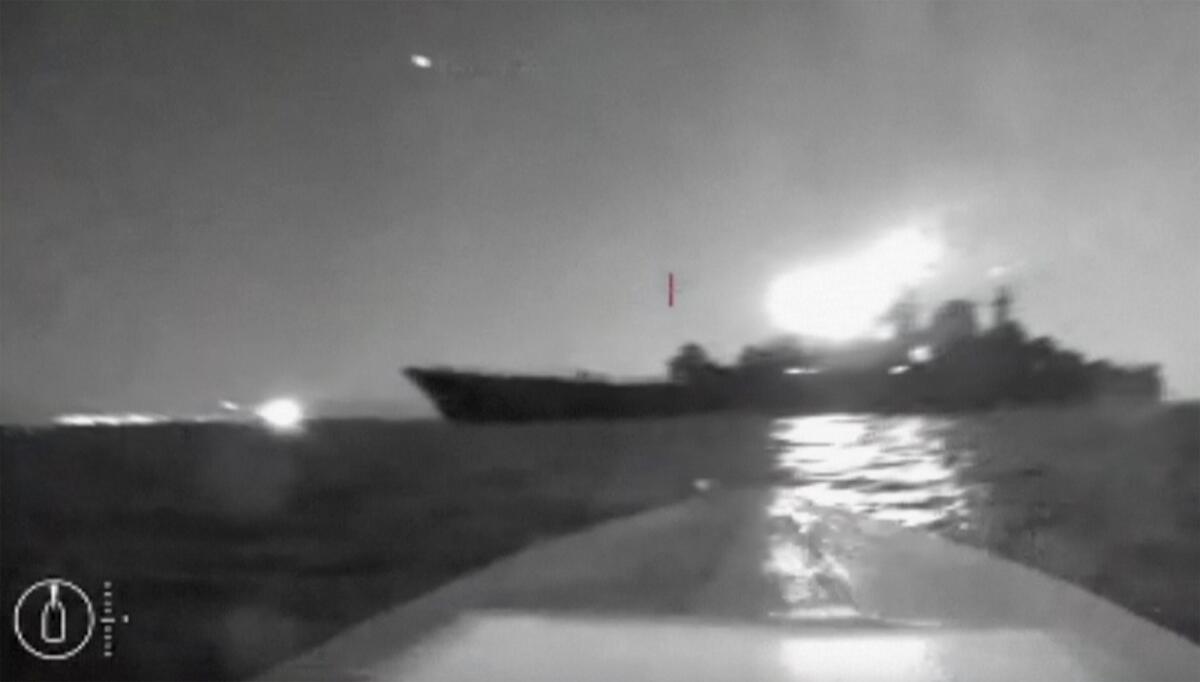 In this screen grab taken from video a drone maneuvers near a  large ship.