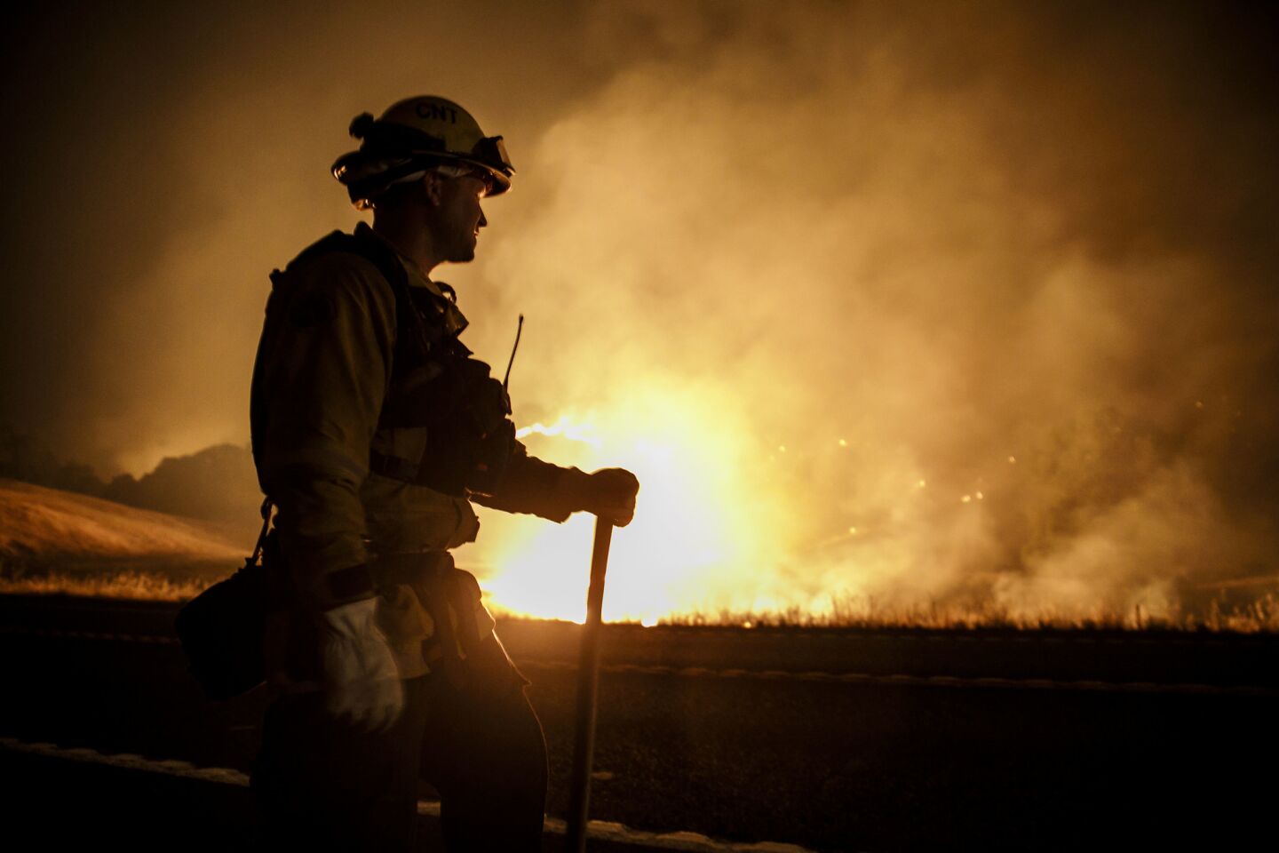 A firefighter monitors a controlled burn along California 20 in Upper Lake on July 31. The Ranch and River fires are burning together as the Mendocino complex fires.