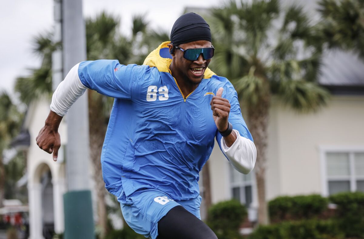 Donald Parham Jr. runs in sunglasses and a hat.