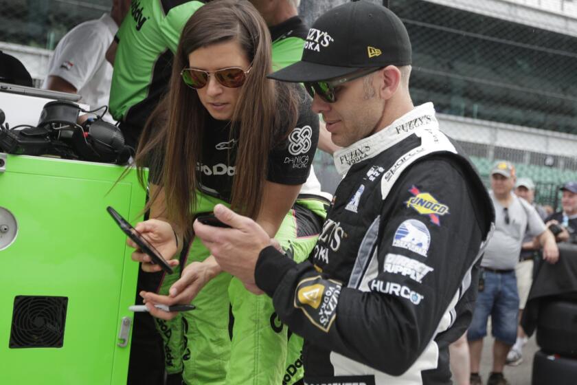 Danica Patrick talks with Ed Carpenter during a rain delay of a practice session for the IndyCar Indianapolis 500 auto race at Indianapolis Motor Speedway, in Indianapolis Monday, May 21, 2018. (AP Photo/Michael Conroy)