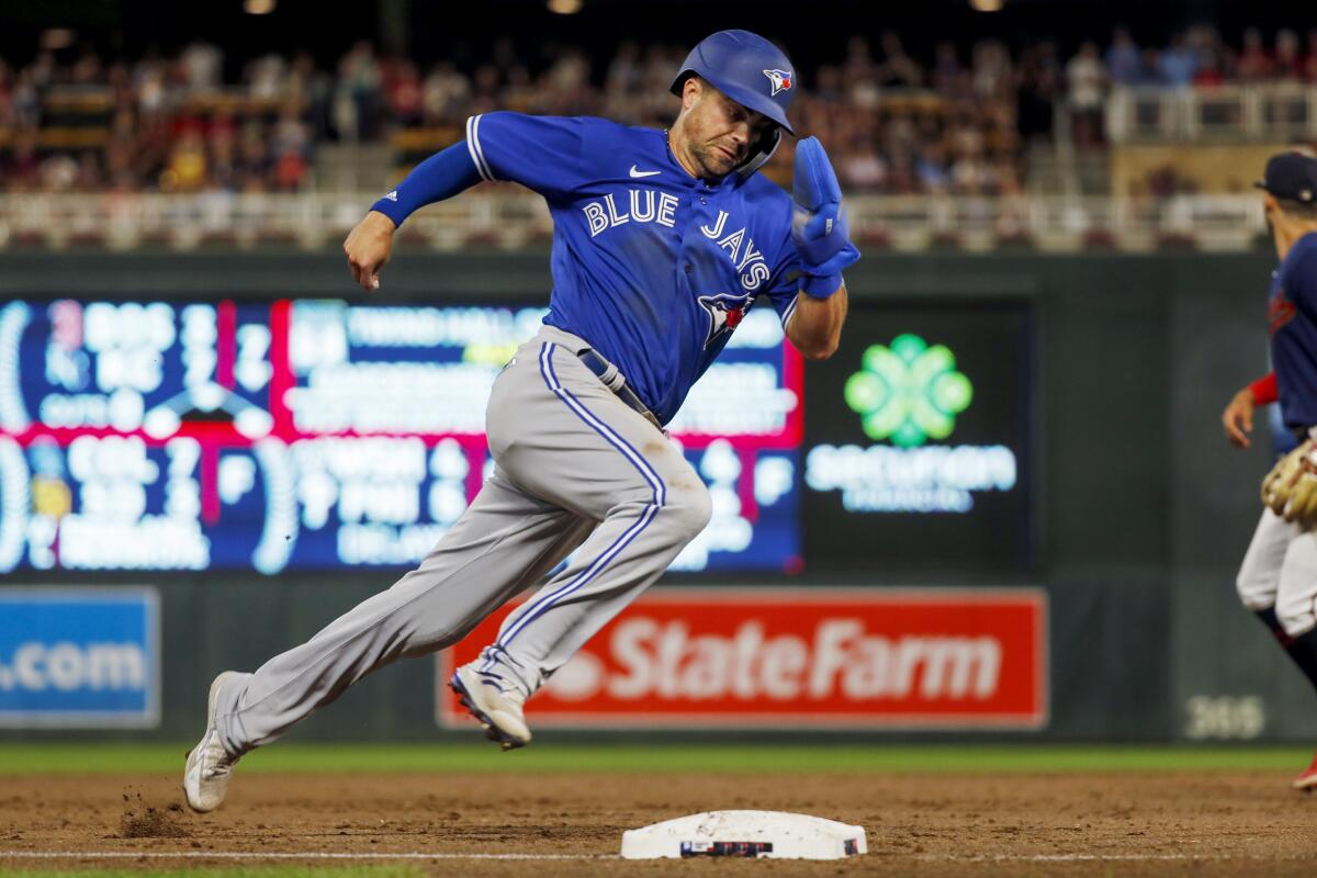 Toronto Blue Jays' Whit Merrifield rounds third and scores from second base against the Minnesota Twins on a two-run single by George Springer during the eighth inning of a baseball game Thursday, Aug. 4, 2022, in Minneapolis. (AP Photo/Bruce Kluckhohn)