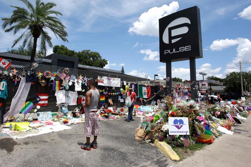Visitors leave items at a makeshift memorial outside the Pulse nightclub in Orlando, Fla. on July 11, 2016.