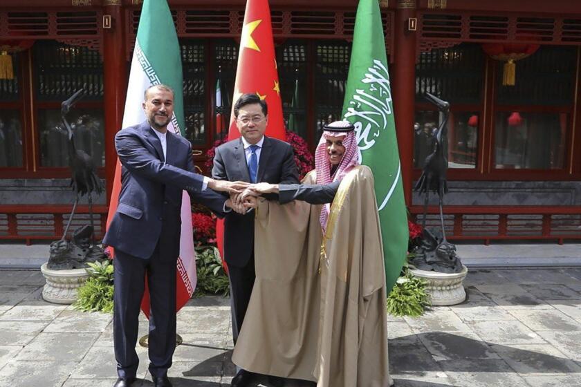 In this picture released by the Iranian Foreign Ministry, Iran's Foreign Minister Hossein Amirabdollahian, left, shakes hands with his Saudi Arabian counterpart Prince Faisal bin Farhan Al Saud, right, and Chineses counterpart Qin Gang in Beijing Thursday, April 6, 2023. (Iranian Foreign Ministry via AP)