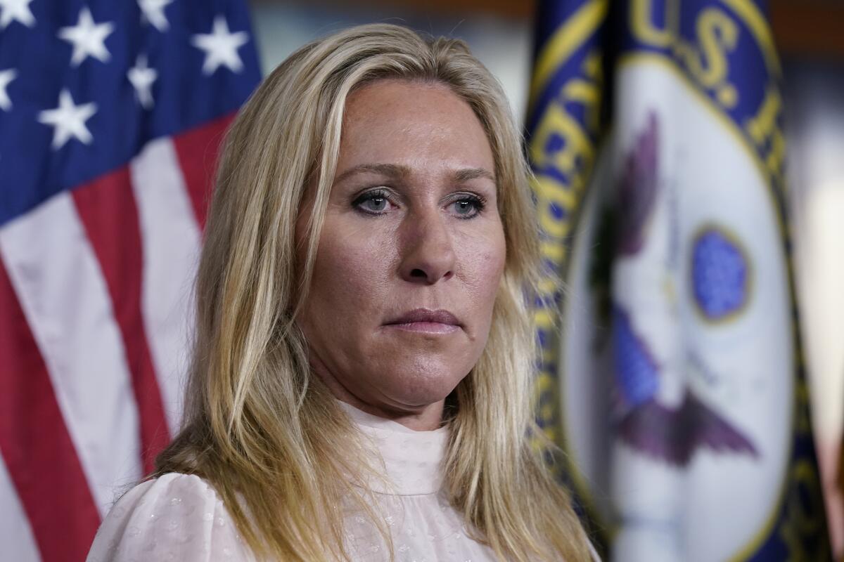 A woman listens to questions at a news conference