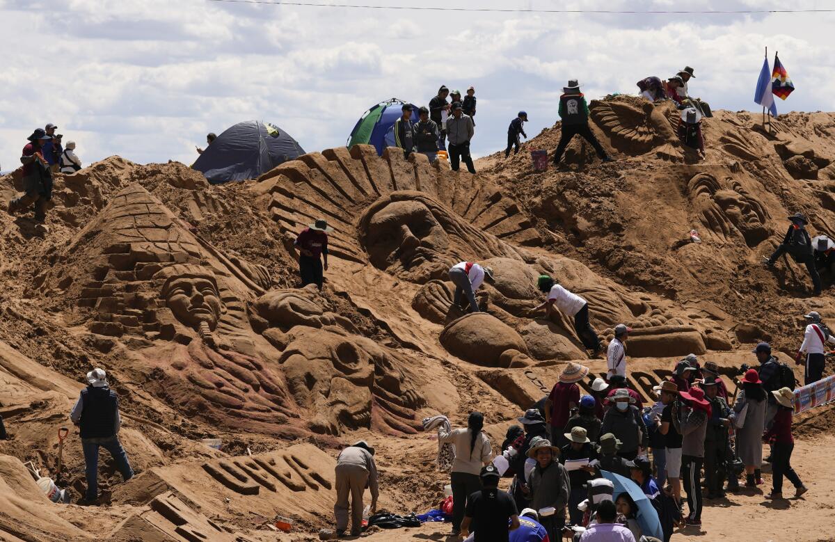 Artistas trabajan en las esculturas de arena con las que se celebra el Viernes Santo en los Arenales de Cochiraya
