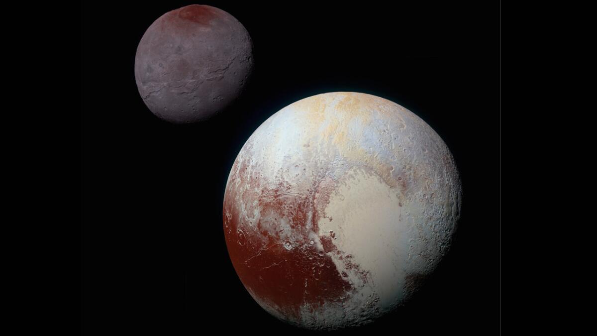 This composite of enhanced color images of Pluto, lower right and Charon was taken by NASA’s New Horizons spacecraft as it passed through the Pluto system on July 14, 2015.