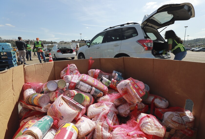  Volunteers place food into the back of cars during the Mass Emergency Food Distribution