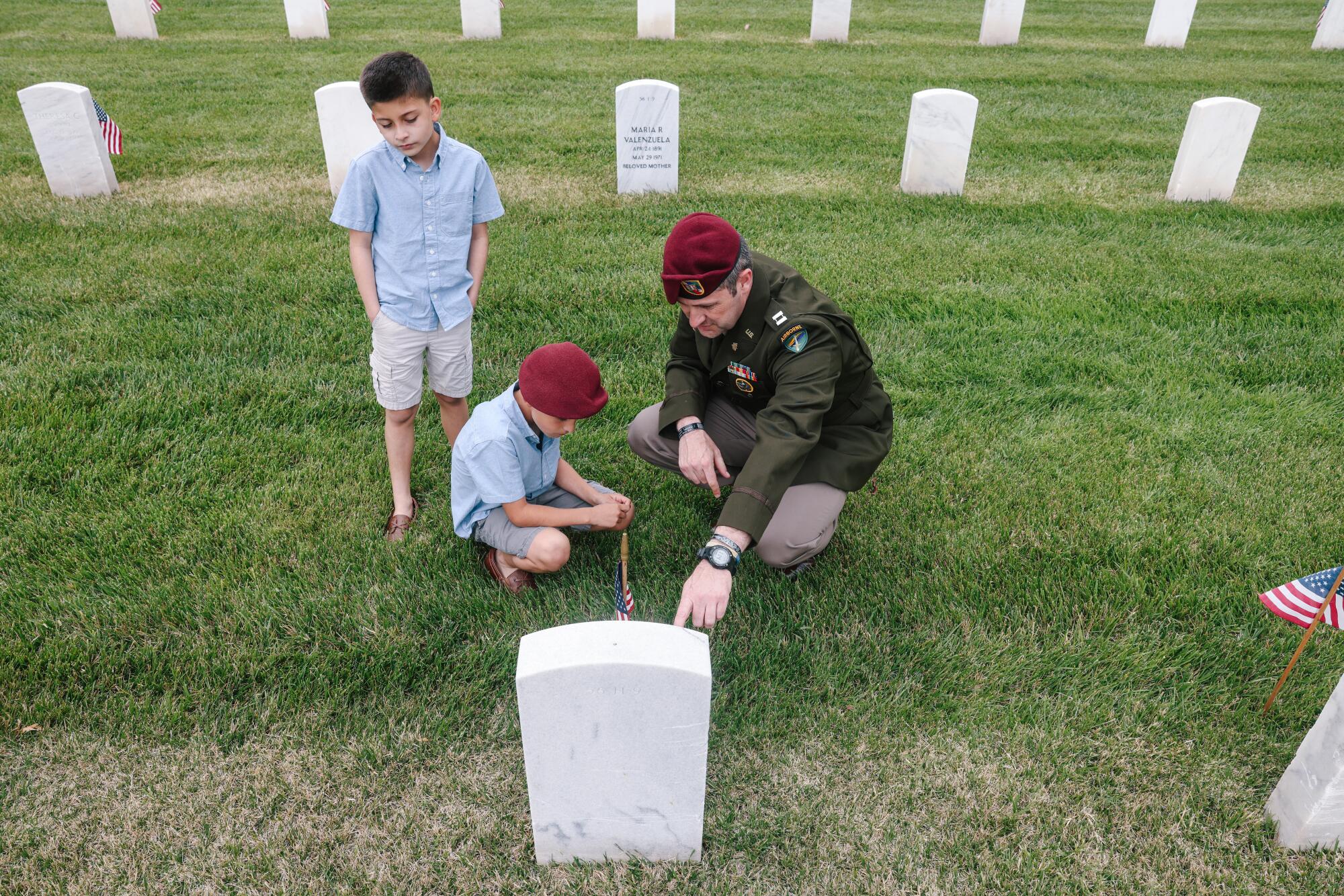 Oliver Kay, a captain in the civil affairs unit spends time with his twin sons Xavier and Max, left and center,