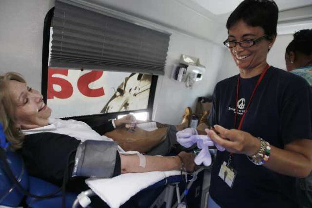 Judy Clegg, left, finishes up, while registered nurse Martha Daez helps Clegg during a blood drive, which took place at Crescenta Valley Sheriff's station on Tuesday, July 17, 2012.