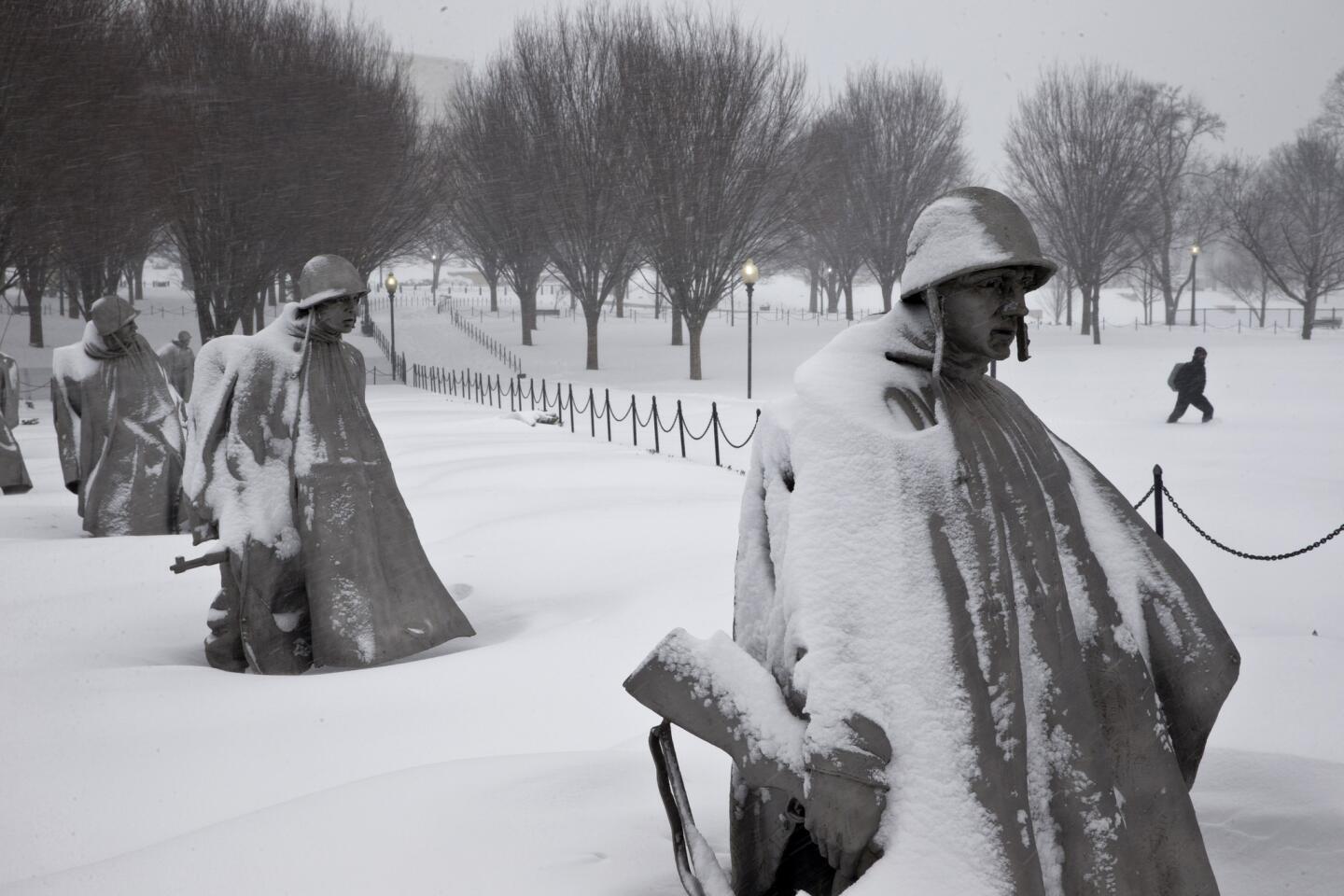 Un peatón camina cerca del monumento a los veteranos de la Guerra de Corea, luego de una nevada el sábado 23 de enero de 2016 en Washington DC. (Foto AP/Alex Brandon)
