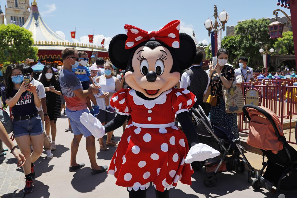 A person wearing a Minnie Mouse cartoon character costume at a theme park