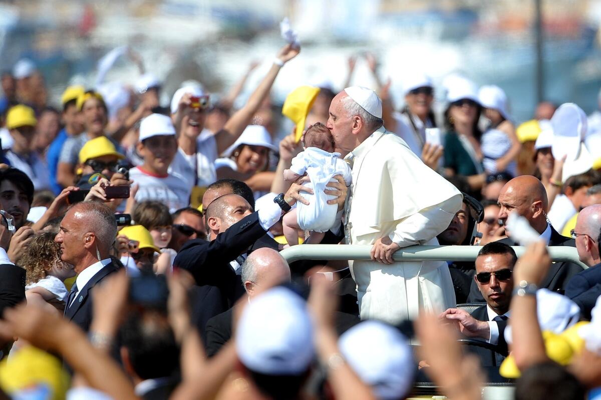 Pope Francis kissesa child as he arrives on the Italian island of Lampedusa on July 8.