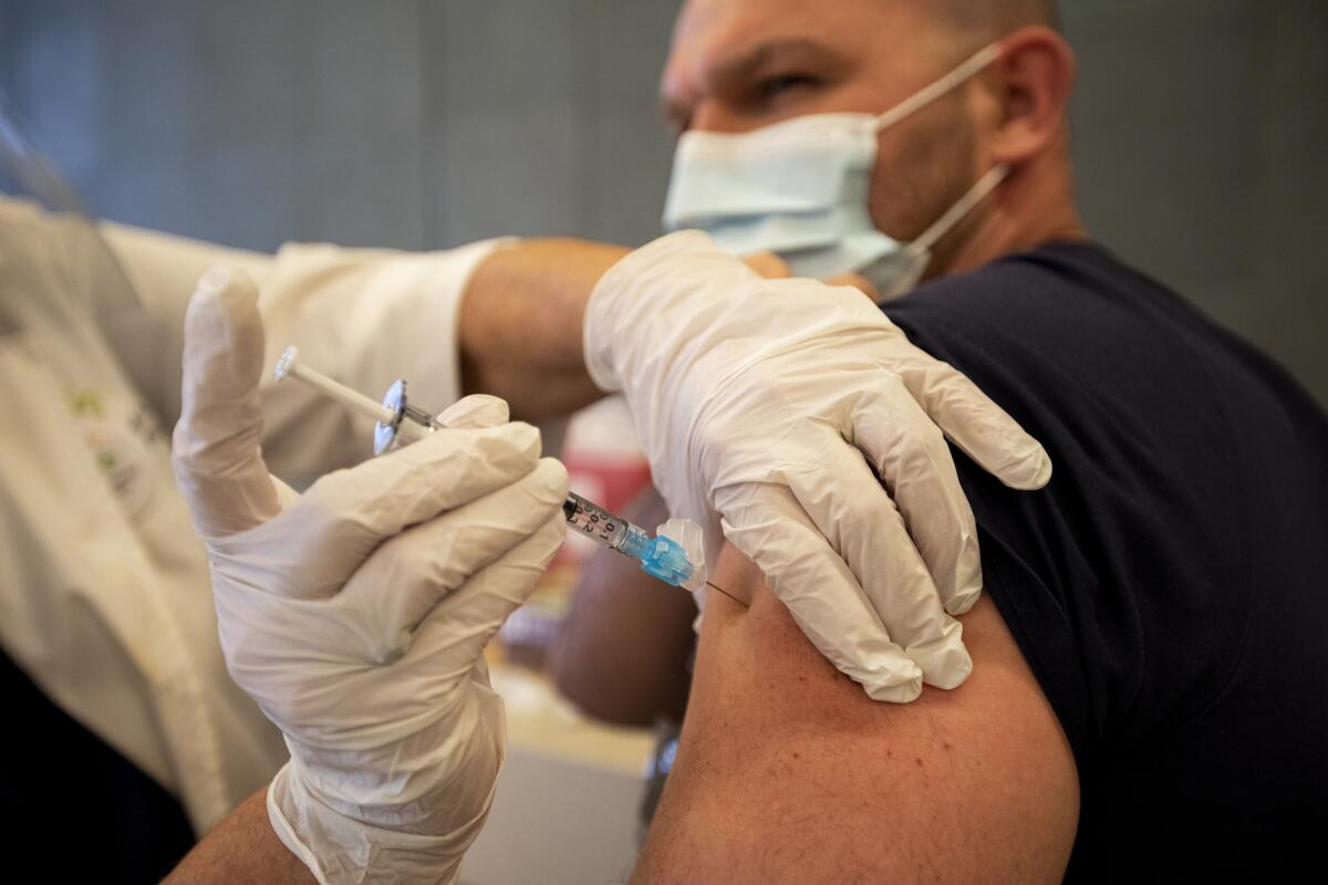 A man gets a vaccine shot in his arm.
