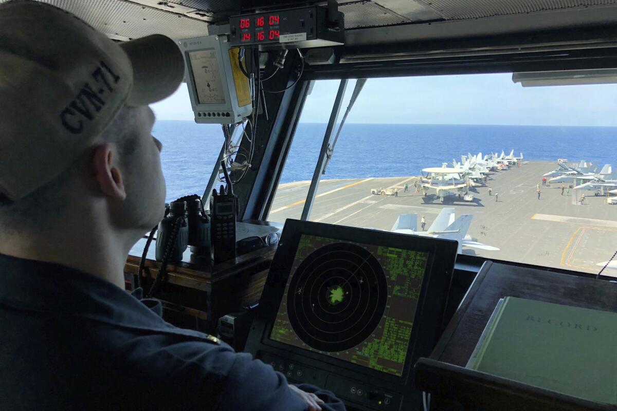 A U.S. Navy crewman monitors the deck of the U.S. aircraft carrier Theodore Roosevelt