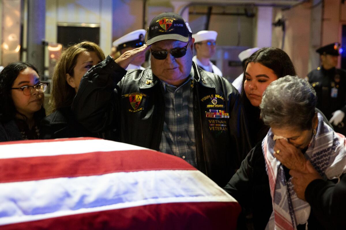 Ruben Valencia salutes as Raul Guerra's casket arrives to LAX after waiting more than 50 years to bring him home. (Dania Maxwell / Los Angeles Times)