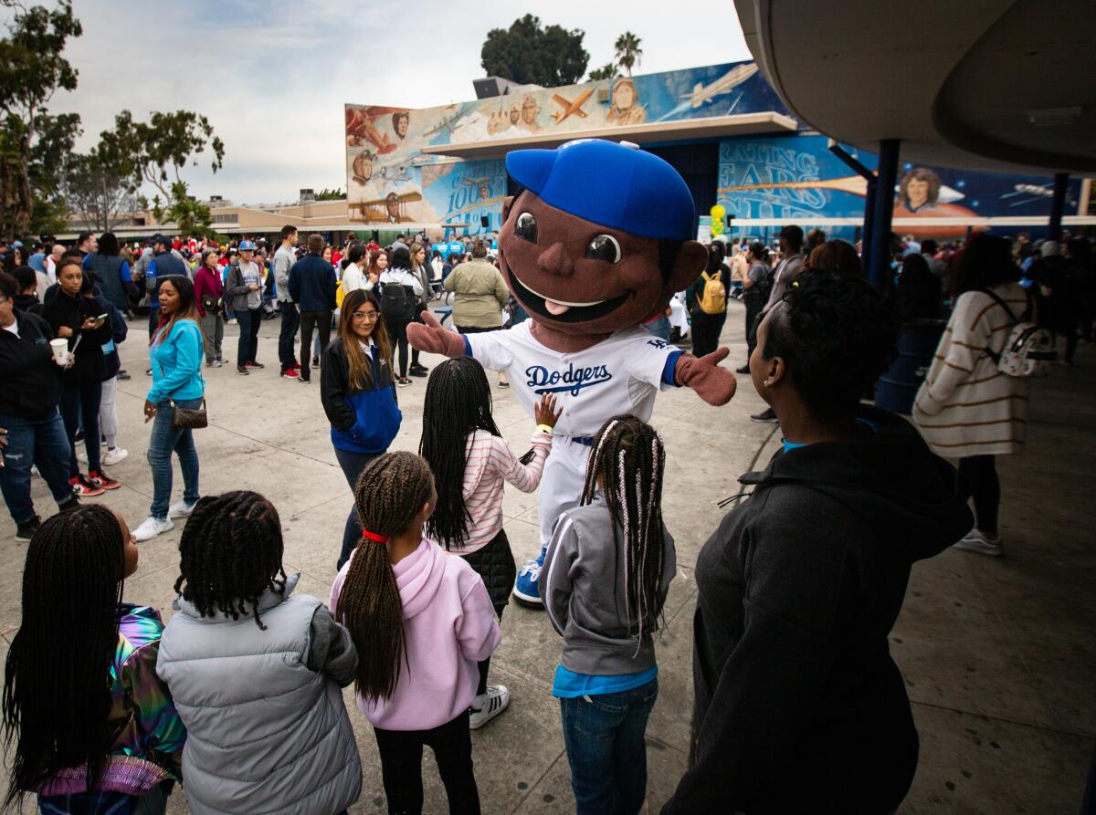 The  Dodgers mascot greets children at the day of service at Orville Wright STEAM Magnet Middle School on Monday.