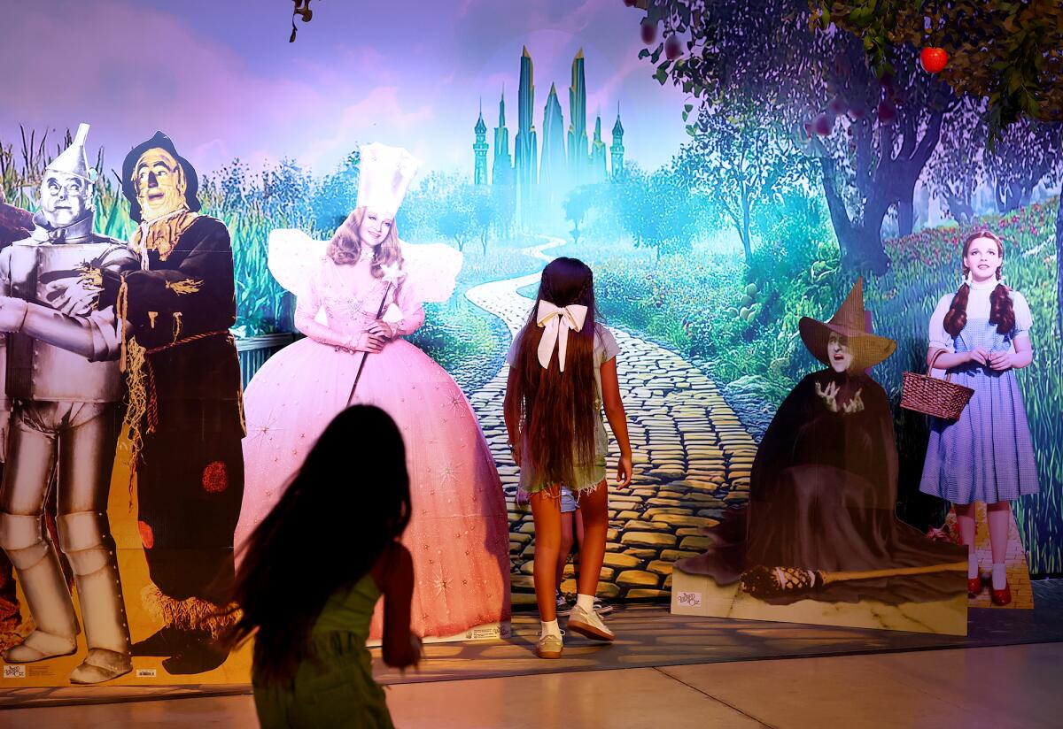 Youngsters pretend to walk down the yellow brick road in a pop-up scene from "The Wizard of Oz" at the O.C. Fair.
