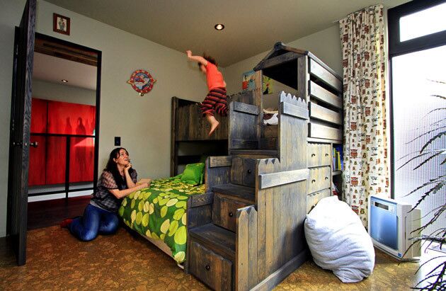 In the boys' bedroom, Indika shows his mom that bunk beds are for more than just sleeping. The floor is cork.