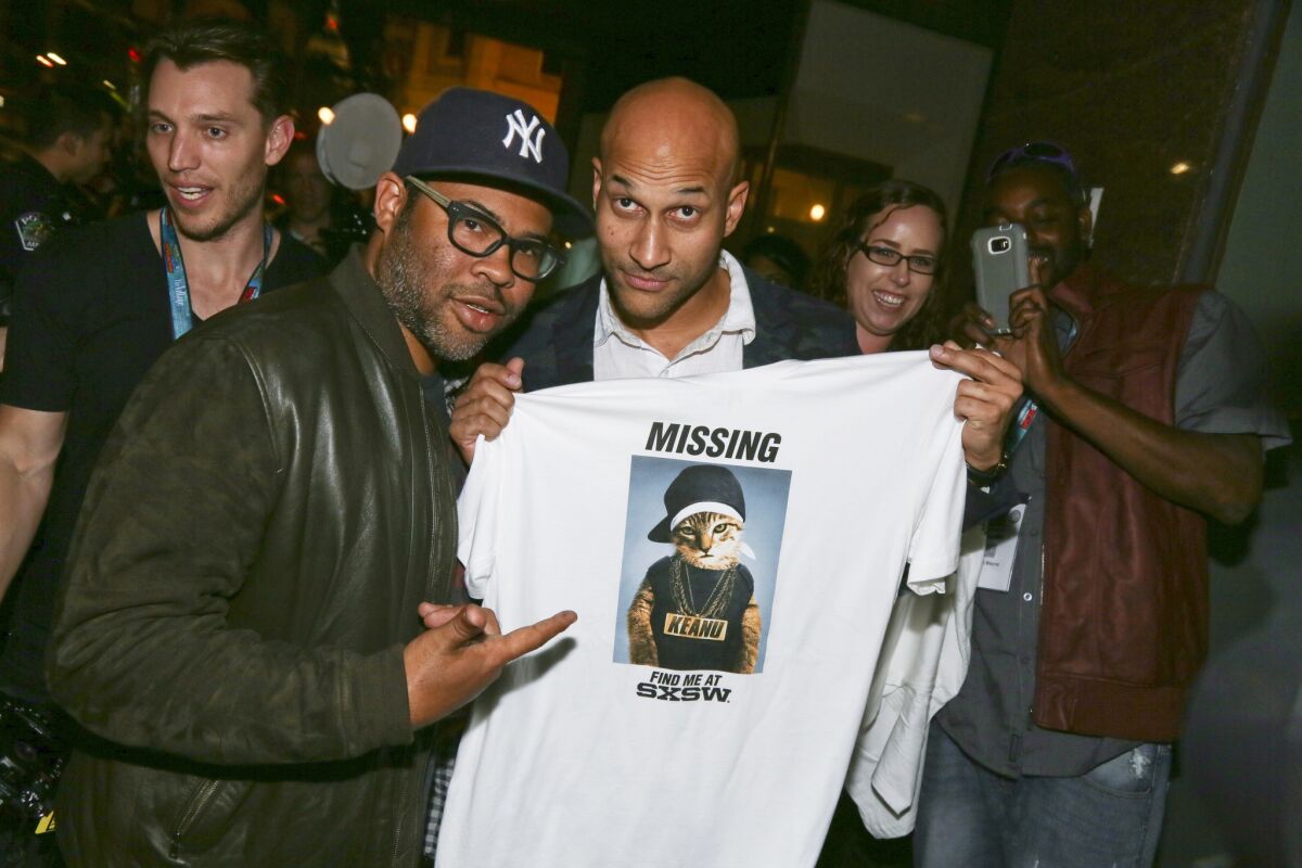 Jordan Peele, left, and Keegan-Michael Key show a T-shirt they handed out at a screening of their work-in-process film "Keanu" at the Paramount Theatre during the South by Southwest Film Festival in Austin, Texas.