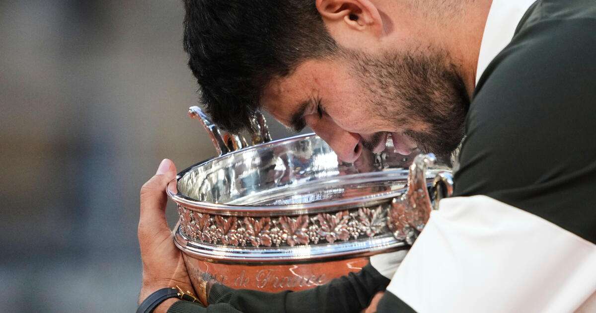 Photo: latimes.com ARCHIVO - Carlos Alcaraz acaricia el trofeo de campeón tras vencer a Jannik Sinner en la final del Abierto de Francia, el